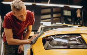 Technician hand detailing yellow sports car Modesto CA
